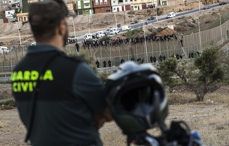 Un guardia civil vigila la frontera de Melilla, sobre cuya valla permanecen numerosos inmigrantes. Un guardia civil vigila la frontera de Melilla, sobre cuya valla permanecen numerosos inmigrantes.