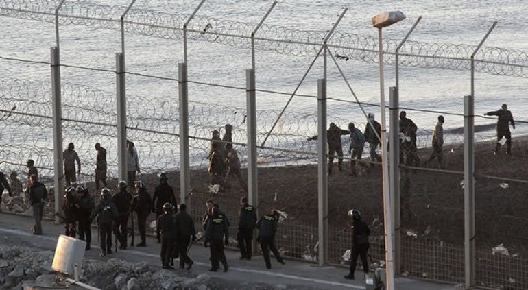 Guardias civiles e inmigrantes en la valla fronteriza del Tarajal, en Ceuta Guardias civiles e inmigrantes en la valla fronteriza del Tarajal, en Ceuta