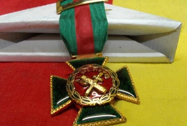 Cruz de la Orden del Mérito de la Guardia Civil con distintivo rojo.
