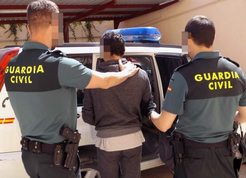 Dos guardias civiles conducen a un detenido. Dos guardias civiles conducen a un detenido.