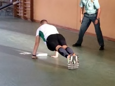 Un agente realiza flexiones ante un evaluador. Un agente realiza flexiones ante un evaluador.