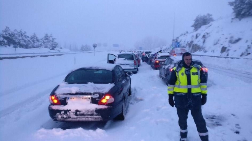 Un guardia civil junto a vehículos atrapados por el temporal en la AP6. Un guardia civil junto a vehículos atrapados por el temporal en la AP6.