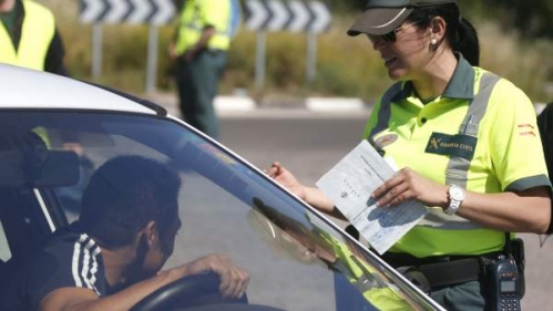 Una guardia civil de Tráfico solicita su documentación a un conductor. Una guardia civil de Tráfico solicita su documentación a un conductor.