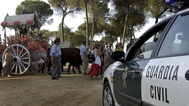 Un vehículo de la Guardia Civil ante participantes en la romería de El Rocío. Un vehículo de la Guardia Civil ante participantes en la romería de El Rocío.