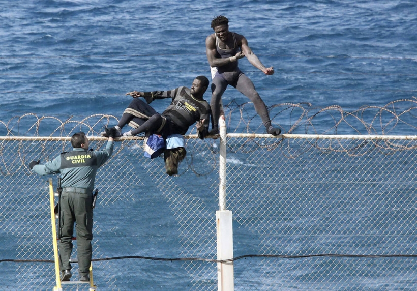 Un guardia civil trata de repeler un asalto de inmigrantes a la valla de Ceuta. Foto: EFE Un guardia civil trata de repeler un asalto de inmigrantes a la valla de Ceuta. Foto: EFE