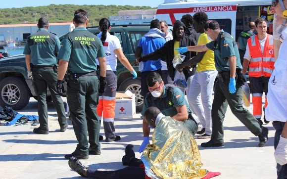 Guardias civiles atienden a inmigrantes recién llegados a la costa. Guardias civiles atienden a inmigrantes recién llegados a la costa.