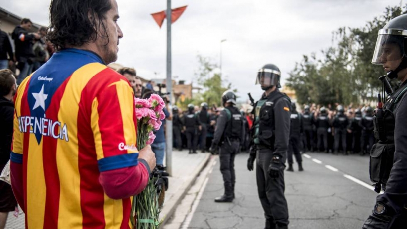 Un manifestante independentista ante guardias civiles. Un manifestante independentista ante guardias civiles.