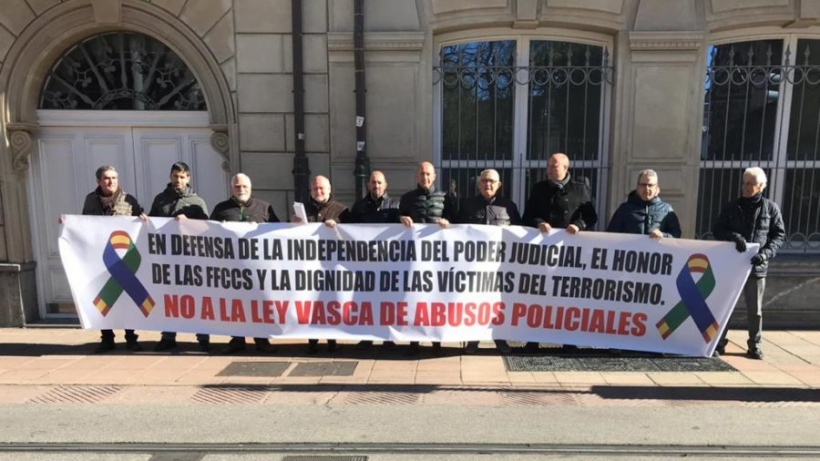 Representantes de AUGC y otras organizaciones policiales muestran su pancarca contra la ley vasca aprobada hoy.
