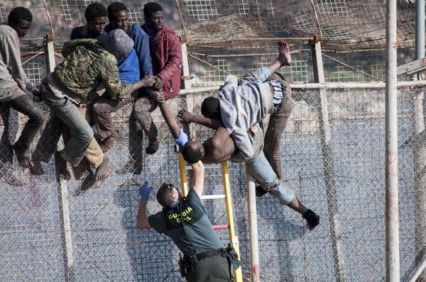 Un guardia civil se enfrenta a un intento de saltar la valla por parte de un grupo de inmigrantes subsaharianos. Un guardia civil se enfrenta a un intento de saltar la valla por parte de un grupo de inmigrantes subsaharianos.